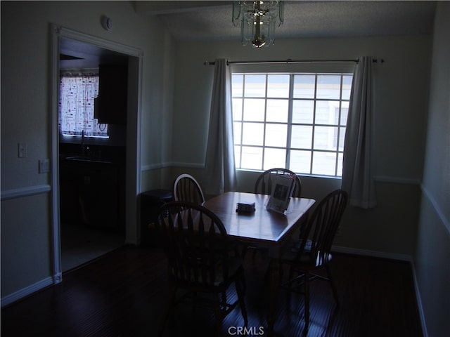 dining space with a textured ceiling, a chandelier, and wood-type flooring