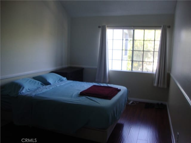 bedroom with dark hardwood / wood-style flooring