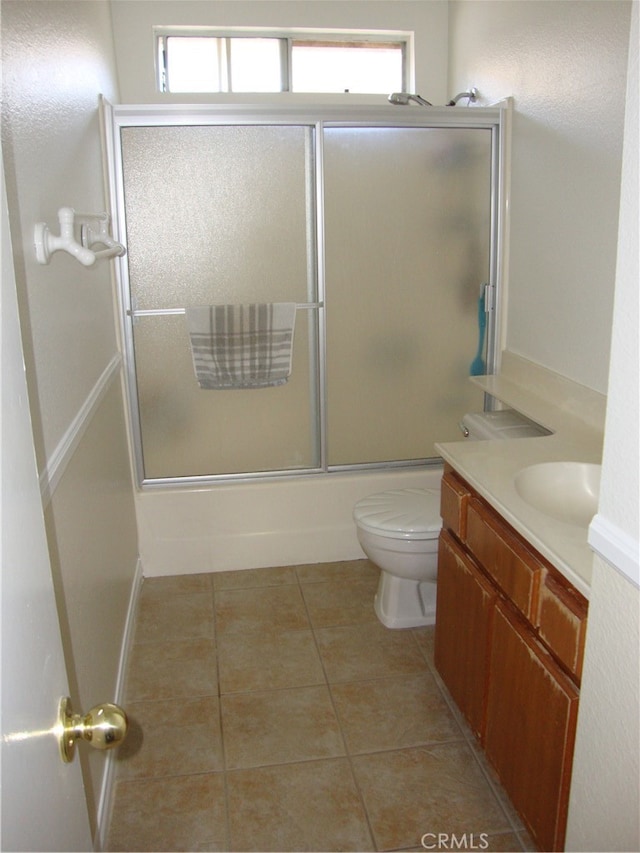 full bathroom with a wealth of natural light, vanity, toilet, and tile patterned floors