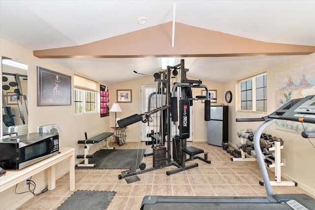 workout area featuring light tile patterned floors and lofted ceiling