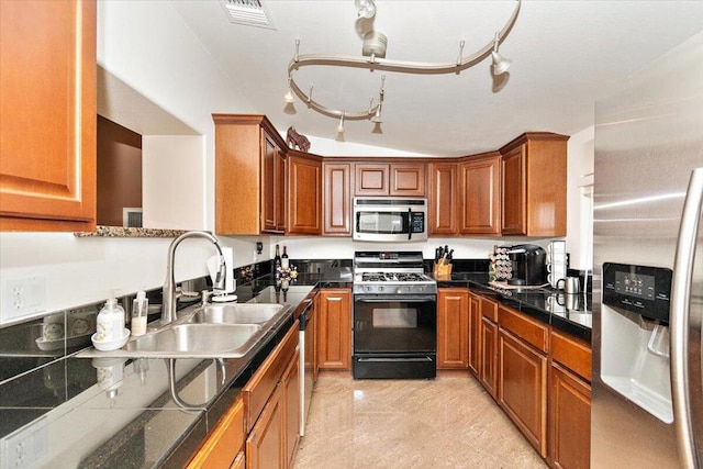 kitchen with appliances with stainless steel finishes, lofted ceiling, and sink