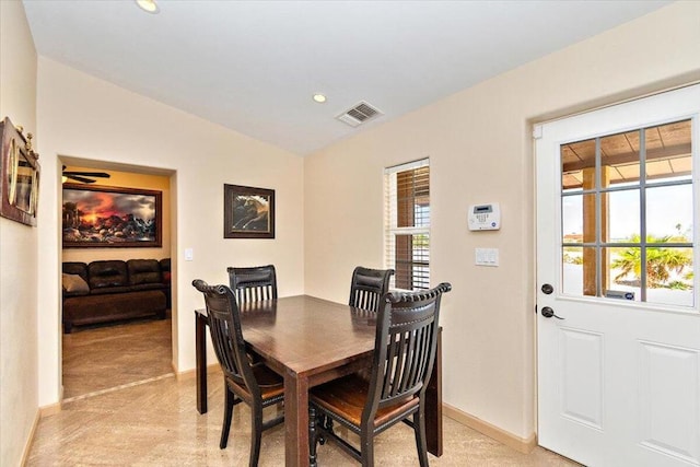 dining room with light carpet, a healthy amount of sunlight, and vaulted ceiling