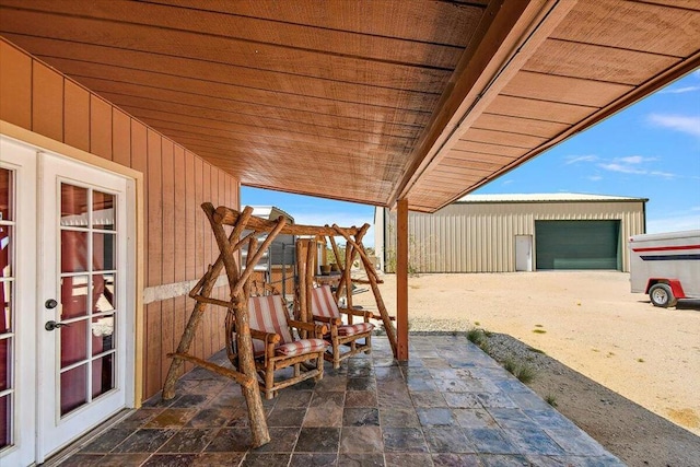 view of patio featuring french doors and a garage