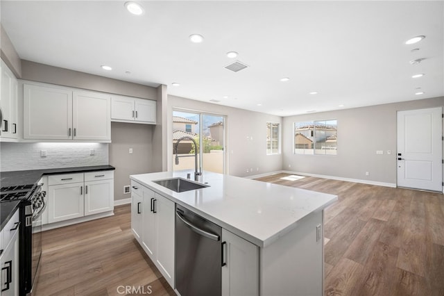 kitchen with sink, white cabinetry, light hardwood / wood-style flooring, and stainless steel appliances