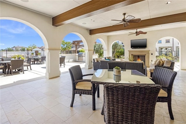 view of patio / terrace featuring an outdoor bar, ceiling fan, and exterior fireplace