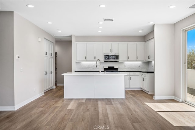 kitchen with white cabinetry, light hardwood / wood-style floors, stainless steel appliances, and sink