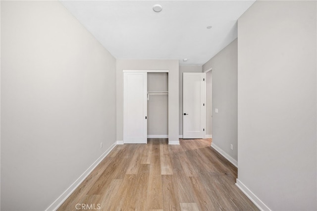 unfurnished bedroom featuring light hardwood / wood-style flooring and a closet