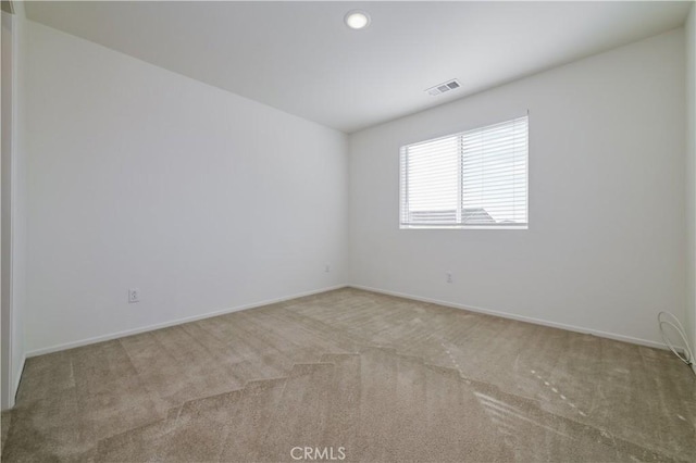 spare room featuring light colored carpet