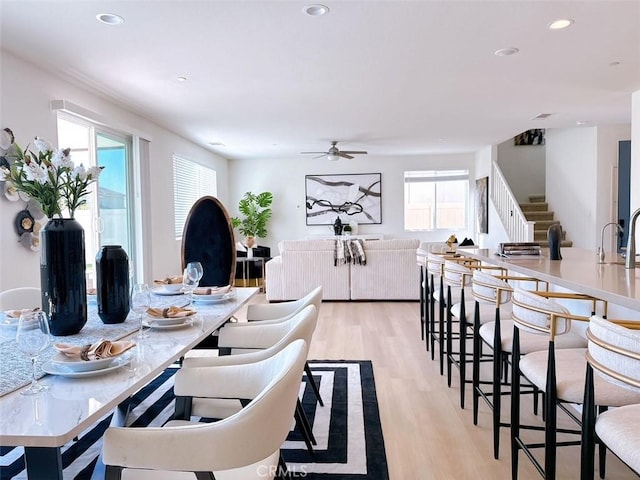 dining area featuring ceiling fan, sink, and light hardwood / wood-style floors