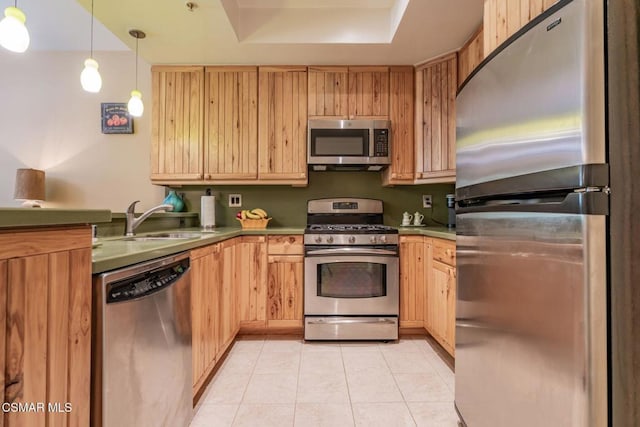 kitchen with appliances with stainless steel finishes, sink, light tile patterned flooring, a tray ceiling, and light brown cabinets