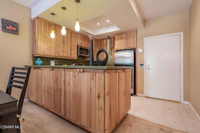 kitchen featuring kitchen peninsula, light brown cabinets, hanging light fixtures, appliances with stainless steel finishes, and light colored carpet