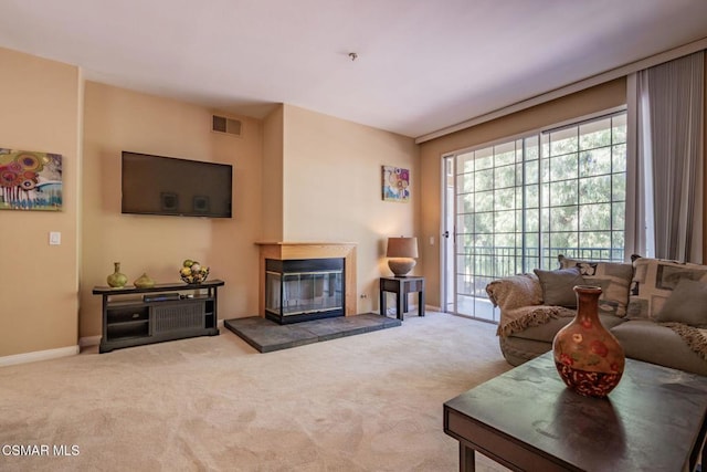 living room with carpet flooring and a tile fireplace