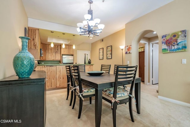 dining space featuring light carpet and an inviting chandelier