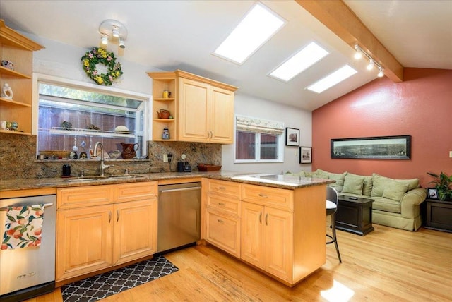 kitchen featuring lofted ceiling with beams, sink, stainless steel dishwasher, and kitchen peninsula