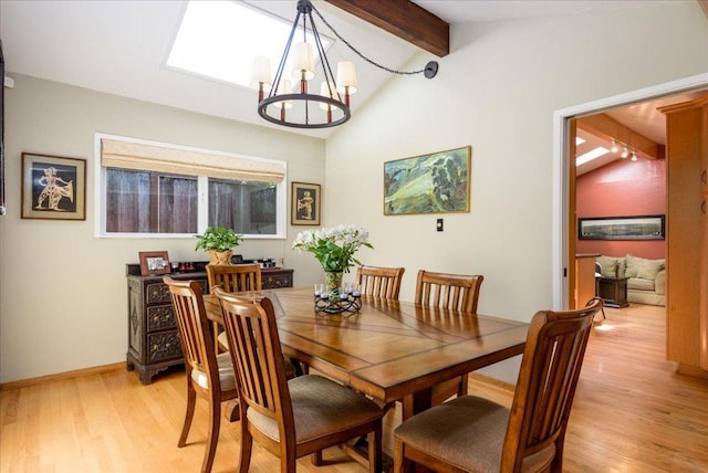 dining space featuring a chandelier, lofted ceiling with beams, and light hardwood / wood-style flooring