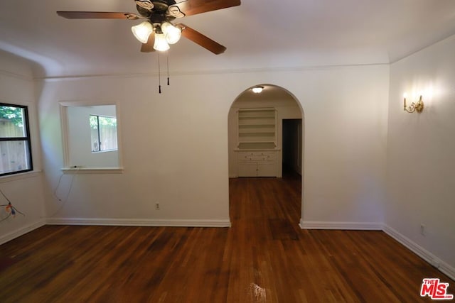 unfurnished room with dark wood-type flooring and ceiling fan