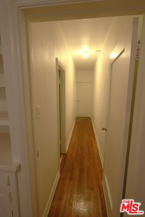 hallway with dark hardwood / wood-style floors