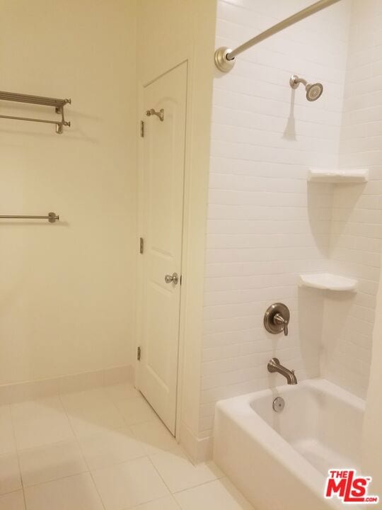 bathroom featuring tiled shower / bath and tile patterned flooring