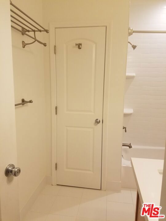 bathroom featuring vanity, shower / tub combination, and tile patterned floors