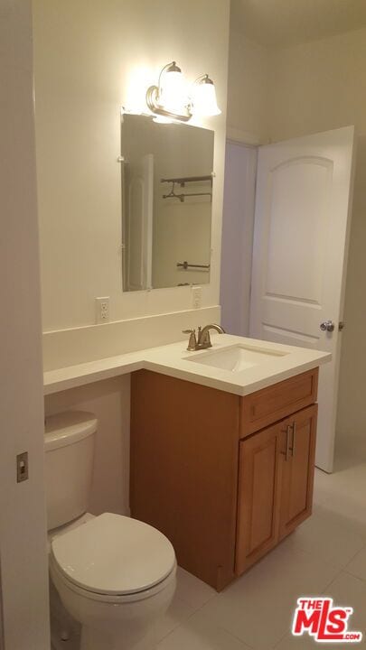 bathroom featuring vanity, toilet, and tile patterned flooring