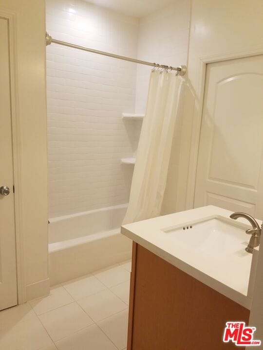 bathroom featuring vanity, shower / tub combo with curtain, and tile patterned flooring