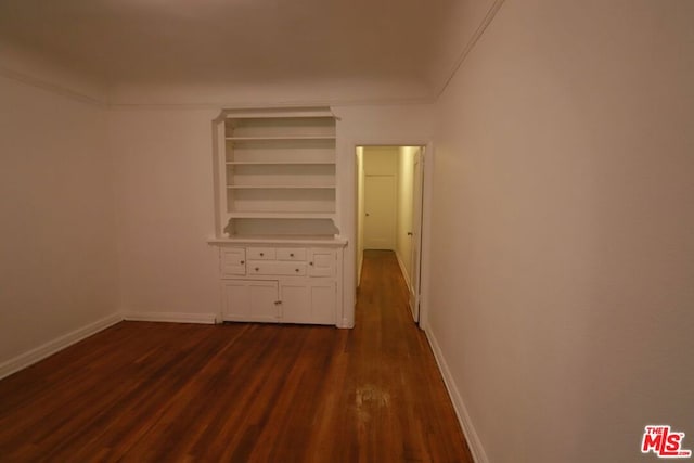 unfurnished bedroom featuring ornamental molding and dark hardwood / wood-style floors