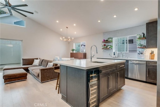 kitchen featuring dishwasher, beverage cooler, a healthy amount of sunlight, and an island with sink