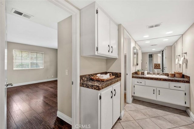 kitchen with sink, light tile patterned floors, and white cabinetry