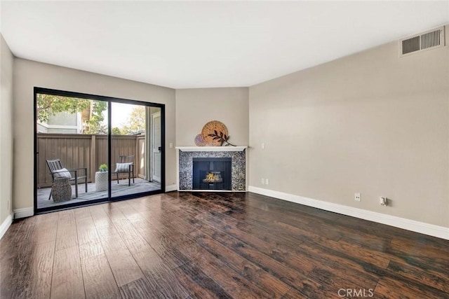 unfurnished living room featuring a tiled fireplace and hardwood / wood-style floors