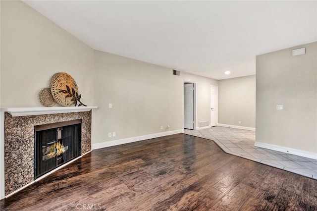 unfurnished living room with a high end fireplace and hardwood / wood-style floors