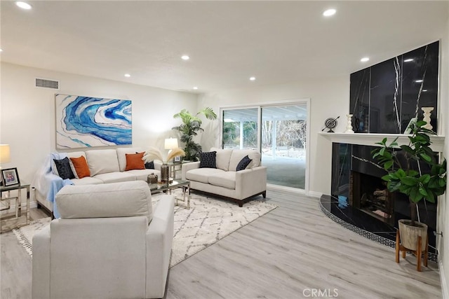 living room featuring a fireplace and light hardwood / wood-style flooring