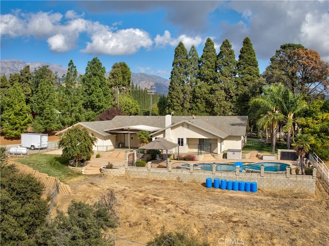 rear view of house featuring a mountain view and a patio area