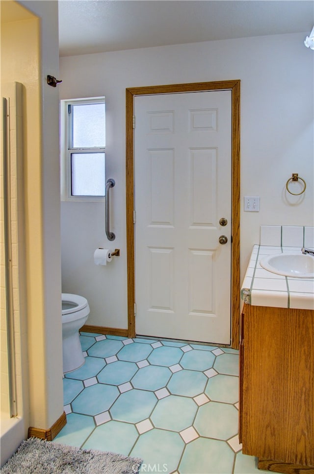 bathroom featuring vanity, toilet, and a shower