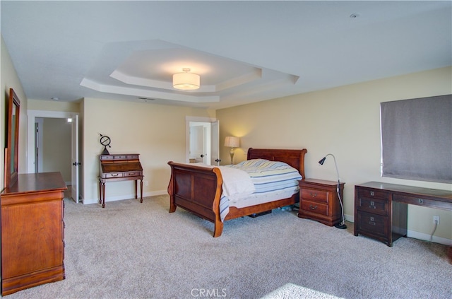 carpeted bedroom with a tray ceiling