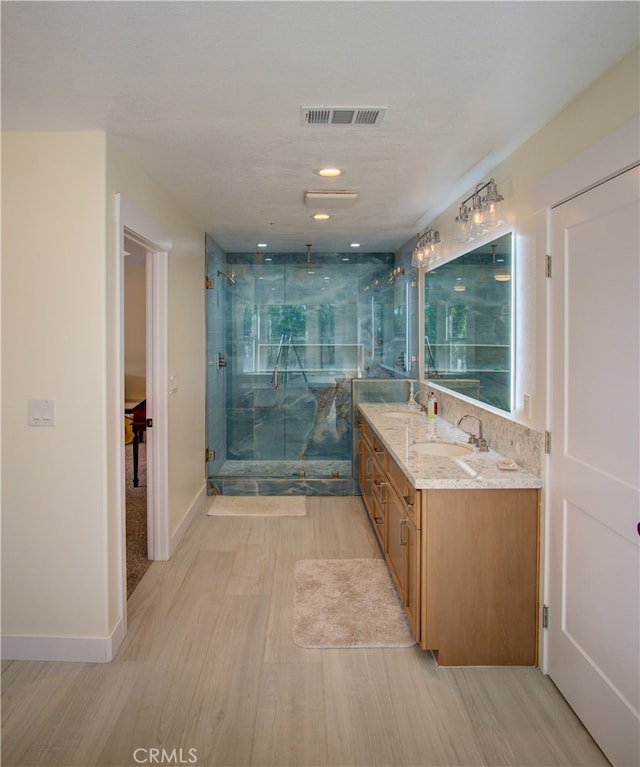 bathroom featuring vanity, an enclosed shower, and hardwood / wood-style flooring