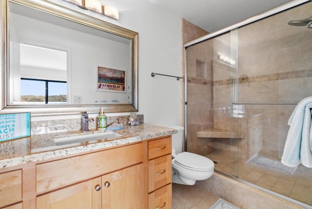 bathroom with toilet, vanity, tile patterned floors, and an enclosed shower