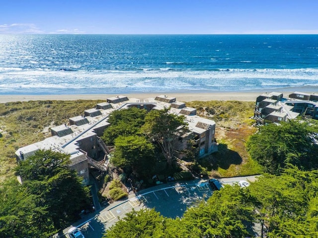 birds eye view of property with a water view and a beach view