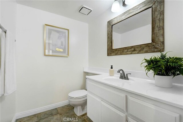 bathroom featuring vanity, tile patterned floors, and toilet