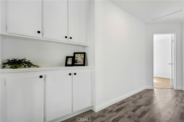 bar with wood-type flooring and white cabinets