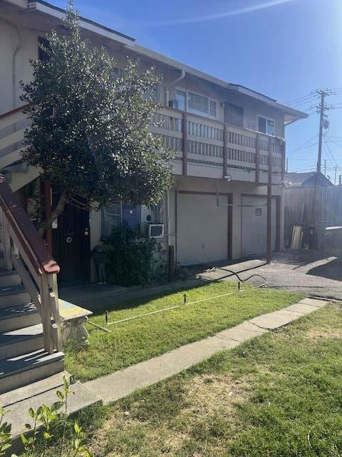 exterior space featuring a balcony, a patio area, and a front lawn