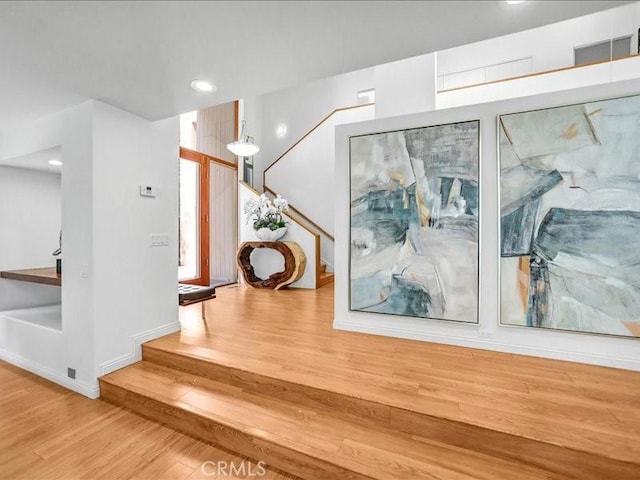 staircase featuring wood finished floors and recessed lighting