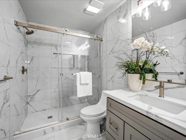 full bath with tile walls, vanity, toilet, a marble finish shower, and marble finish floor