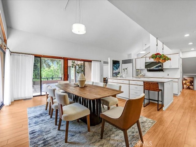 dining space featuring recessed lighting, a high ceiling, and light wood-style flooring