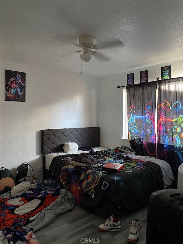 bedroom featuring hardwood / wood-style flooring, a textured ceiling, and ceiling fan