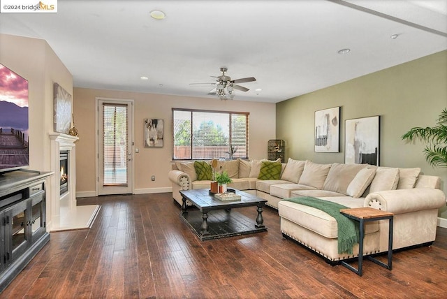 living room with dark wood-type flooring and ceiling fan