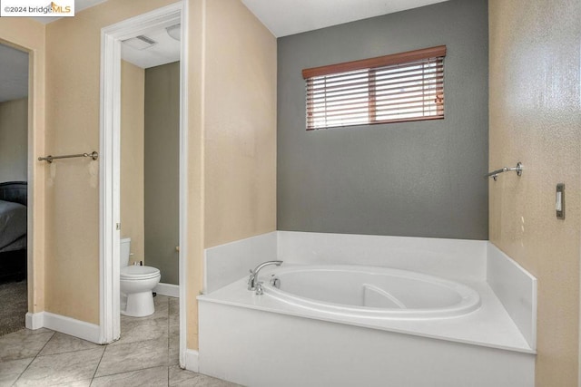 bathroom featuring toilet, a tub, and tile patterned flooring