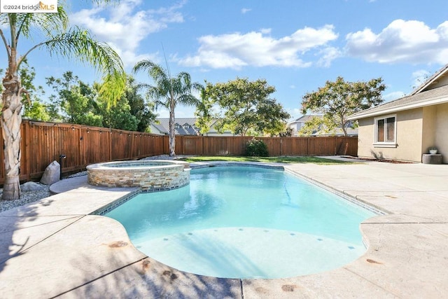 view of pool with an in ground hot tub and a patio