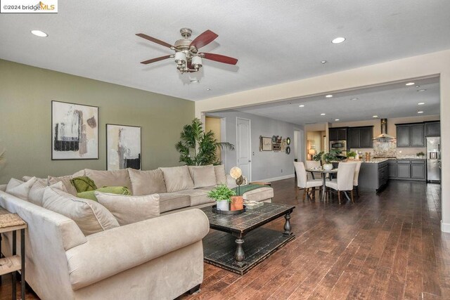 living room with dark hardwood / wood-style floors and ceiling fan