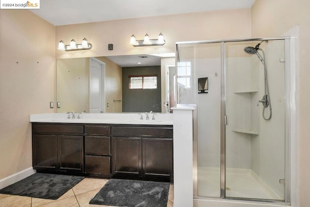 bathroom with vanity, tile patterned floors, and a shower with door