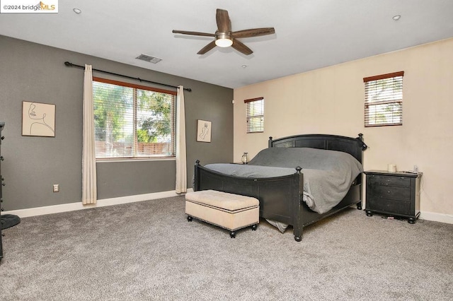 carpeted bedroom featuring ceiling fan and multiple windows